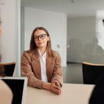 Mulher participa de uma entrevista de emprego em um escritório moderno.