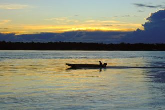 Rio de Porto Velho, em Rondônia, ao entardecer, com uma embarcação no horizonte