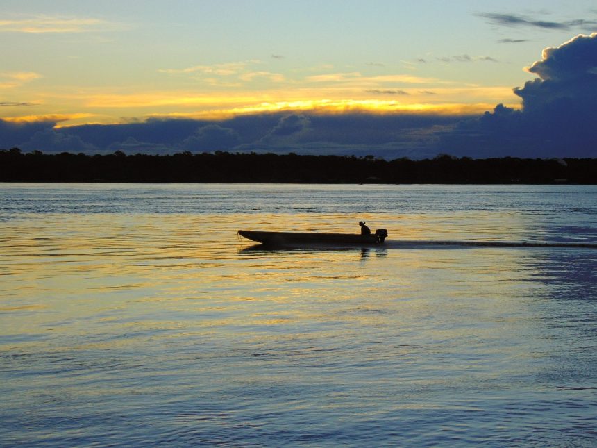 Rio de Porto Velho, em Rondônia, ao entardecer, com uma embarcação no horizonte